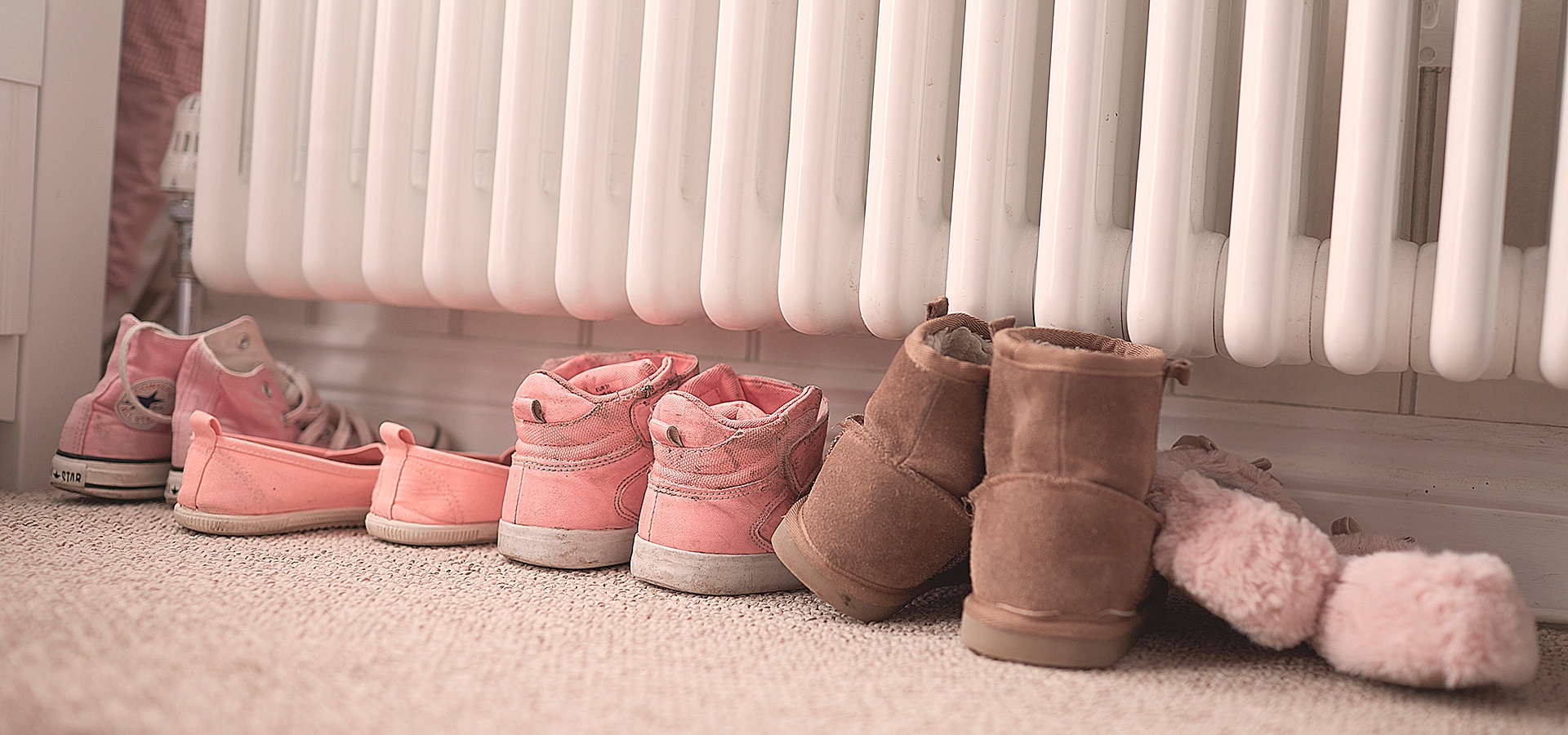 5 par sko står under en radiator